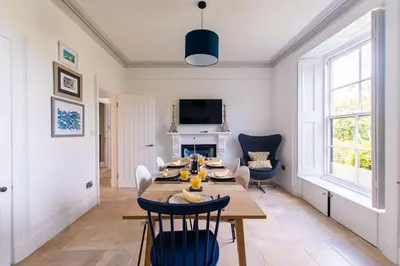 a dining room with a table and chairs and a fireplace at Primrose Cottage in St Ives