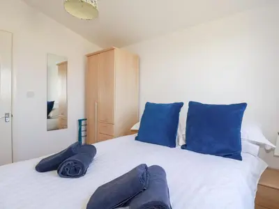 a bedroom with blue pillows on a white bed at 224 Atlantic Bays in Padstow