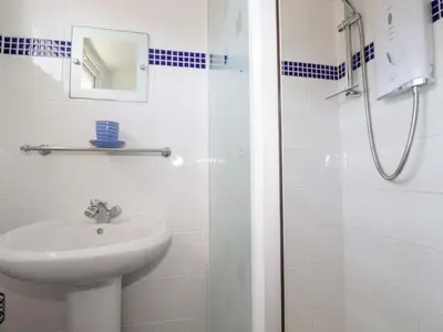 a white bathroom with a sink and a shower at 224 Atlantic Bays in Padstow