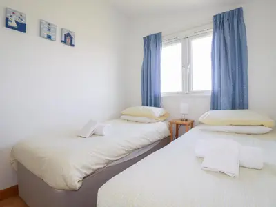 two twin beds in a room with a window at 224 Atlantic Bays in Padstow