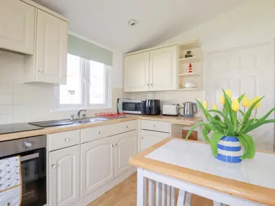 a kitchen with white cabinets and a potted plant at 224 Atlantic Bays in Padstow