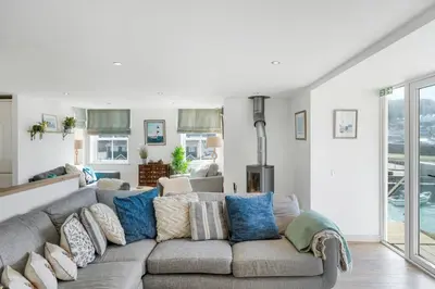 a living room with a gray couch with blue pillows at Harbour Master's House in Portreath