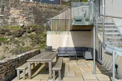 a table and chairs on a patio with stairs at Harbour Master's House in Portreath
