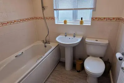 a bathroom with a sink and a toilet and a bath tub at The Honeypot - Cornish Apartment close to Eden Project & beaches in Par