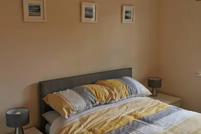 a bedroom with a bed with pillows and two lamps at The Honeypot - Cornish Apartment close to Eden Project & beaches in Par