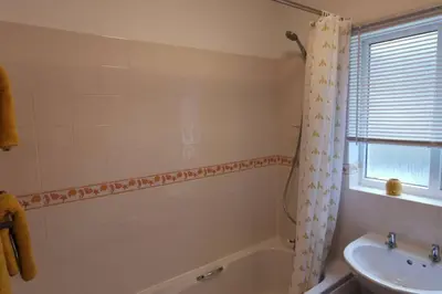 a bathroom with a bath tub and a sink at The Honeypot - Cornish Apartment close to Eden Project & beaches in Par