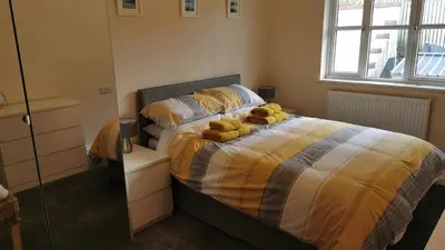 a bedroom with a bed with yellow towels on it at The Honeypot - Cornish Apartment close to Eden Project & beaches in Par