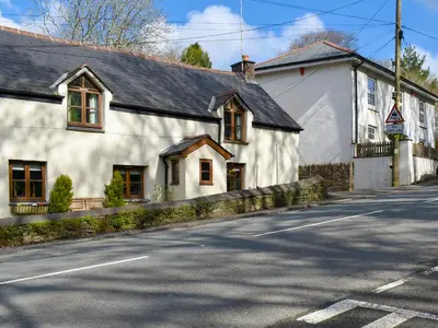 a white building on the side of a street at Pineview Cottage in Downderry