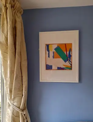 a blue wall with a picture and a curtain at Blue Skies in St Ives
