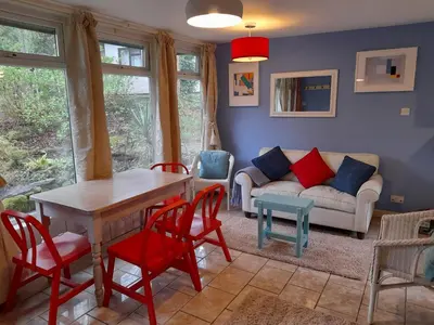 a living room with a table and chairs and a couch at Blue Skies in St Ives