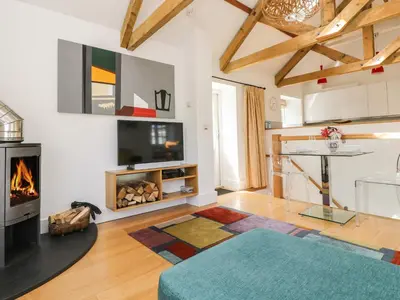 a living room with a fireplace and a tv at Little Chygowlin in Truro
