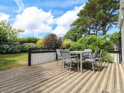 a wooden deck with a table and chairs on it at Little Chygowlin in Truro