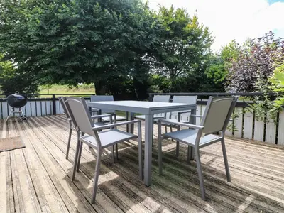 a table and chairs sitting on a deck at Little Chygowlin in Truro
