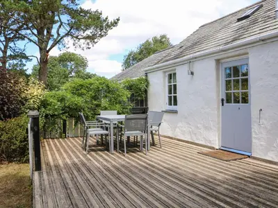a wooden deck with a table and chairs on a house at Little Chygowlin in Truro