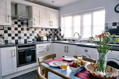 a kitchen with a table with a vase of flowers at Finest Retreats - Charnwood in Lewannick