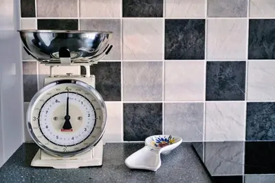 a clock sitting on a counter next to a black and white tiles at Finest Retreats - Charnwood in Lewannick