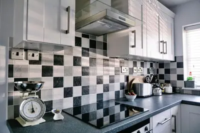 a kitchen with black and white checkered tiles on the wall at Finest Retreats - Charnwood in Lewannick