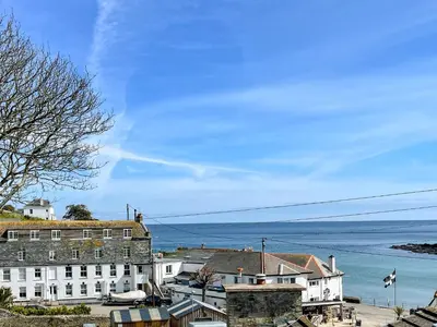 a group of buildings with the ocean in the background at Seatons Rest in Portmellon