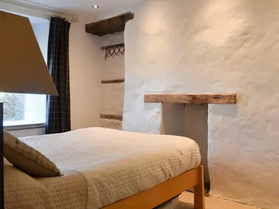 a bedroom with a bed and a table in it at Seatons Rest in Portmellon
