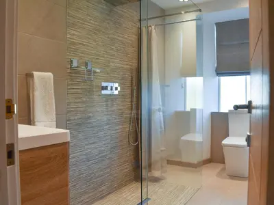 a bathroom with a glass shower and a toilet at Seatons Rest in Portmellon
