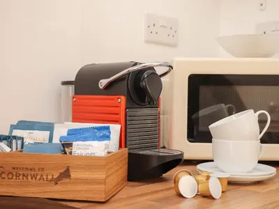 a table with a microwave and a box with a coffee cup at The Old Post Office in Helston