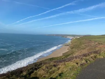 a view of the ocean from a hill with a beach at The Old Post Office in Helston