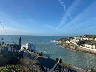 a group of people standing on a hill near the ocean at The Old Post Office in Helston