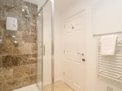 a bathroom with a shower with a glass door at The Old Post Office in Helston