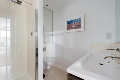 a white bathroom with a sink and a toilet at Ollies 4 Cribbar in Newquay