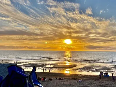 a sunset at the beach with people on the beach at Ollies 4 Cribbar in Newquay