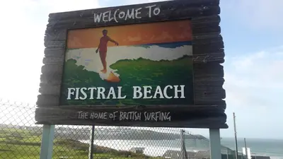 a sign for a beach with a man on a surfboard at Ollies 4 Cribbar in Newquay