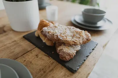 two pastries on a black plate on a table at Ocean 1- Sea View apartment, Fistral Beach Newquay in Newquay