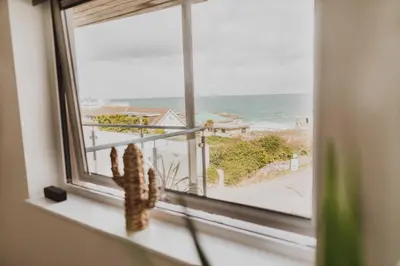 a window with a view of the ocean at Ocean 1- Sea View apartment, Fistral Beach Newquay in Newquay
