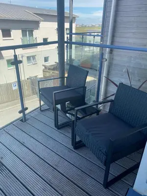 a porch with two chairs and a table on a balcony at Ocean 1- Sea View apartment, Fistral Beach Newquay in Newquay