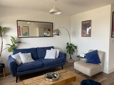 a living room with a blue couch and a mirror at Ocean 1- Sea View apartment, Fistral Beach Newquay in Newquay