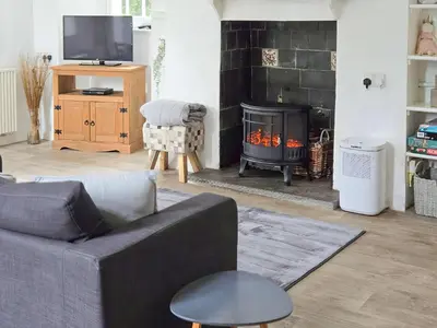 a living room with a couch and a fire place at The Cornish Nook Beautiful Grade 2 Listed Building In Cornwall By STAE-Homes in Camelford