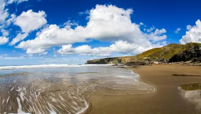 a beach with a cloudy sky and the ocean at The Cornish Nook Beautiful Grade 2 Listed Building In Cornwall By STAE-Homes in Camelford