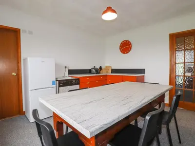 a kitchen with a table and chairs and a refrigerator at Boscastle View in Boscastle