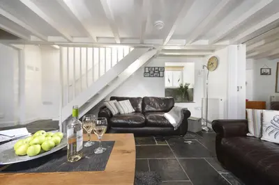 a living room with a table and a couch at Dolor Cottage in Coverack