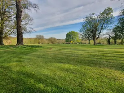 a field of grass with trees in the distance at Blissful Escape Hengar Manor in Bodmin