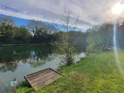 a wooden dock sitting on the side of a lake at Blissful Escape Hengar Manor in Bodmin