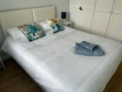 a white bed with two pillows and a towel on it at SunnyVale Valley View Cottage in Gorran Haven