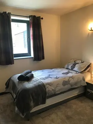 a bedroom with a bed and a window at Trelaske Mill Cider Barn-with Hot Tub, Fire Pit BBQ in Lewannick