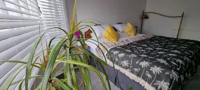 a bedroom with a bed and a plant next to a window at Hidden Gem near the beach with pool table in Newquay
