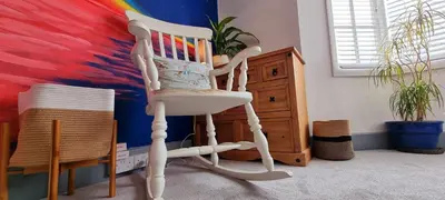 a white rocking chair in a room with a colorful wall at Hidden Gem near the beach with pool table in Newquay