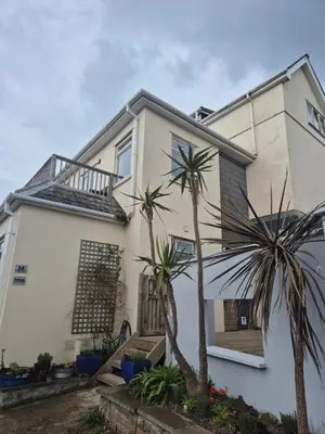 a white house with palm trees in front of it at Hidden Gem near the beach with pool table in Newquay
