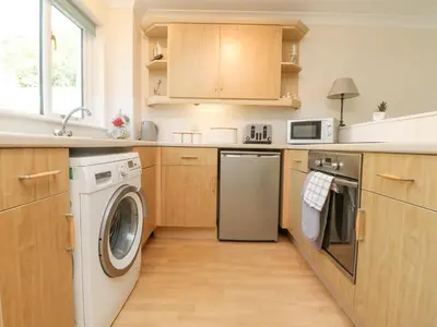a kitchen with a washing machine and a washer at Owls Roost in Falmouth
