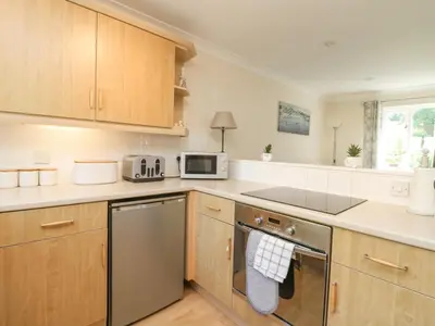 a kitchen with stainless steel appliances and wooden cabinets at Owls Roost in Falmouth