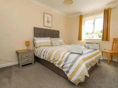 a bedroom with a large bed and a window at Owls Roost in Falmouth