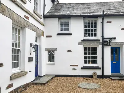 a white house with a blue door at The Cornish Peak Beautiful Apartment In Grade 2 Listed Building In Cornwall By STAE-Homes in Camelford